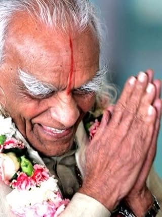 B.K.S. Iyengar, criador do método Iyengar Yoga, de mãos unidas e cabeça baixa