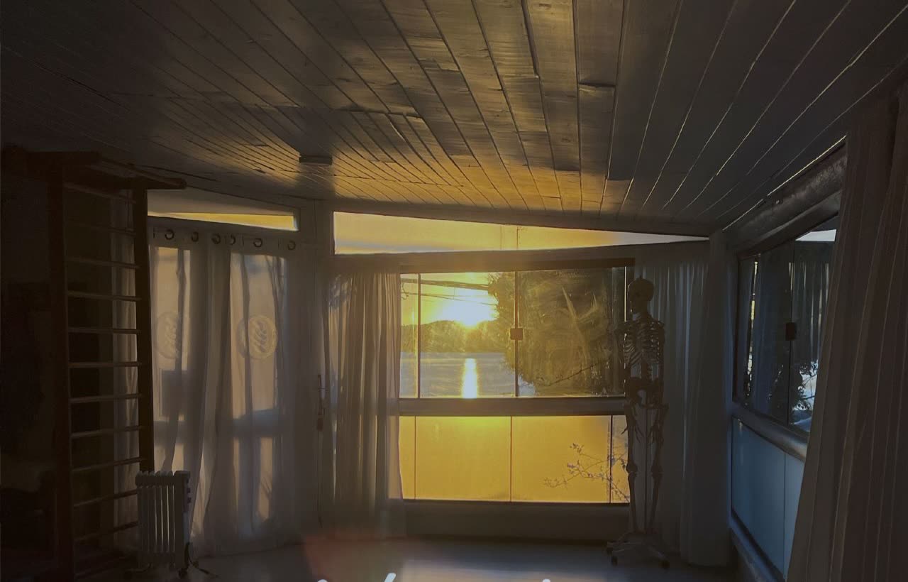 Sala de prática do Yogamar ao entardecer, com vista para a Lagoa da Conceição